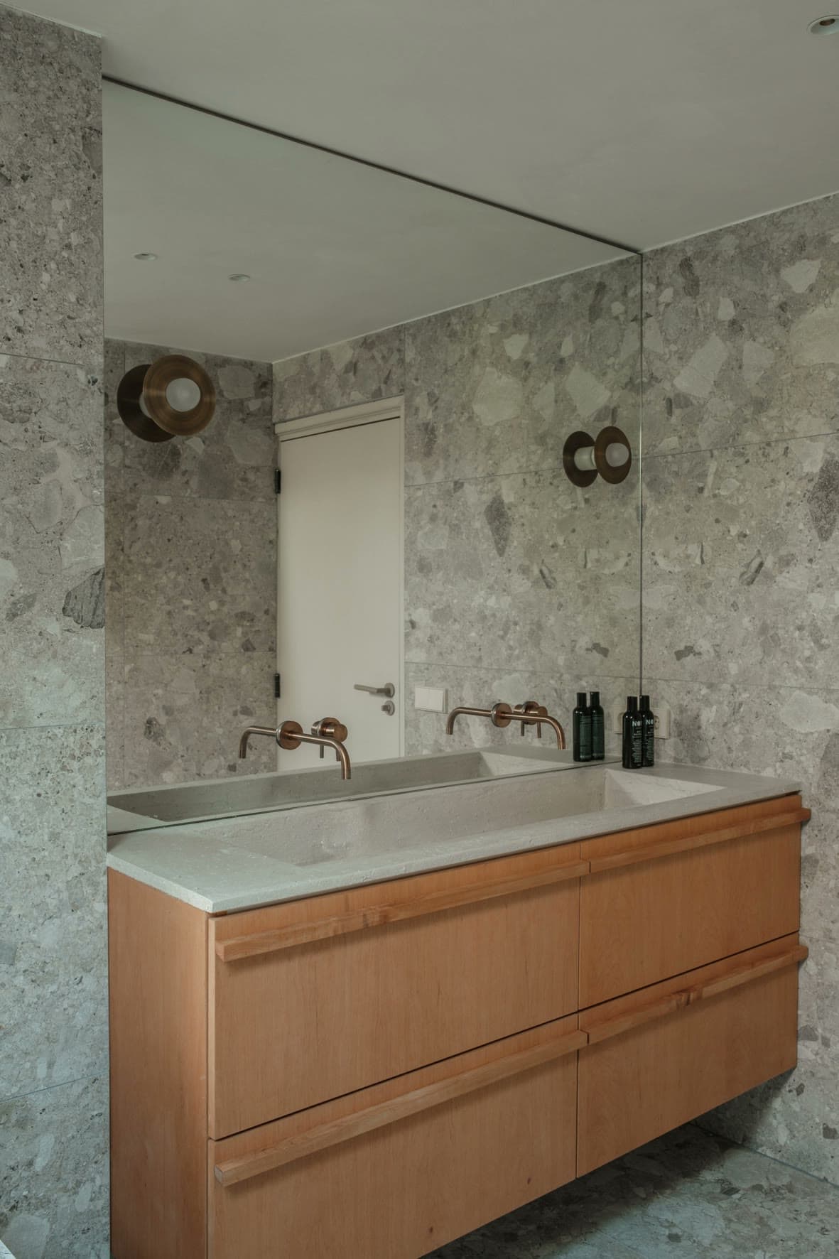 Bathroom in warm lime plaster with a double vanity and timber details