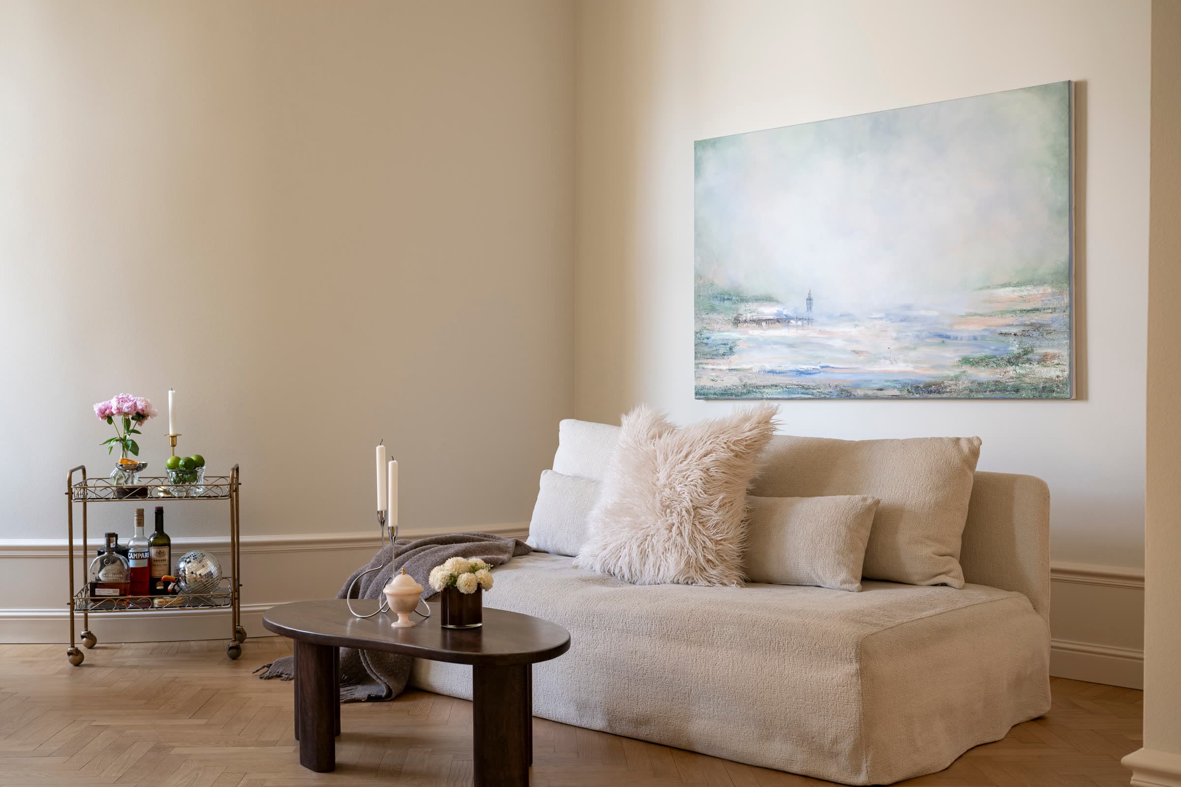 Living room in a renovated turn-of-the-century apartment with herringbone parquet and a bouclé sofa, Vikingagatan 21