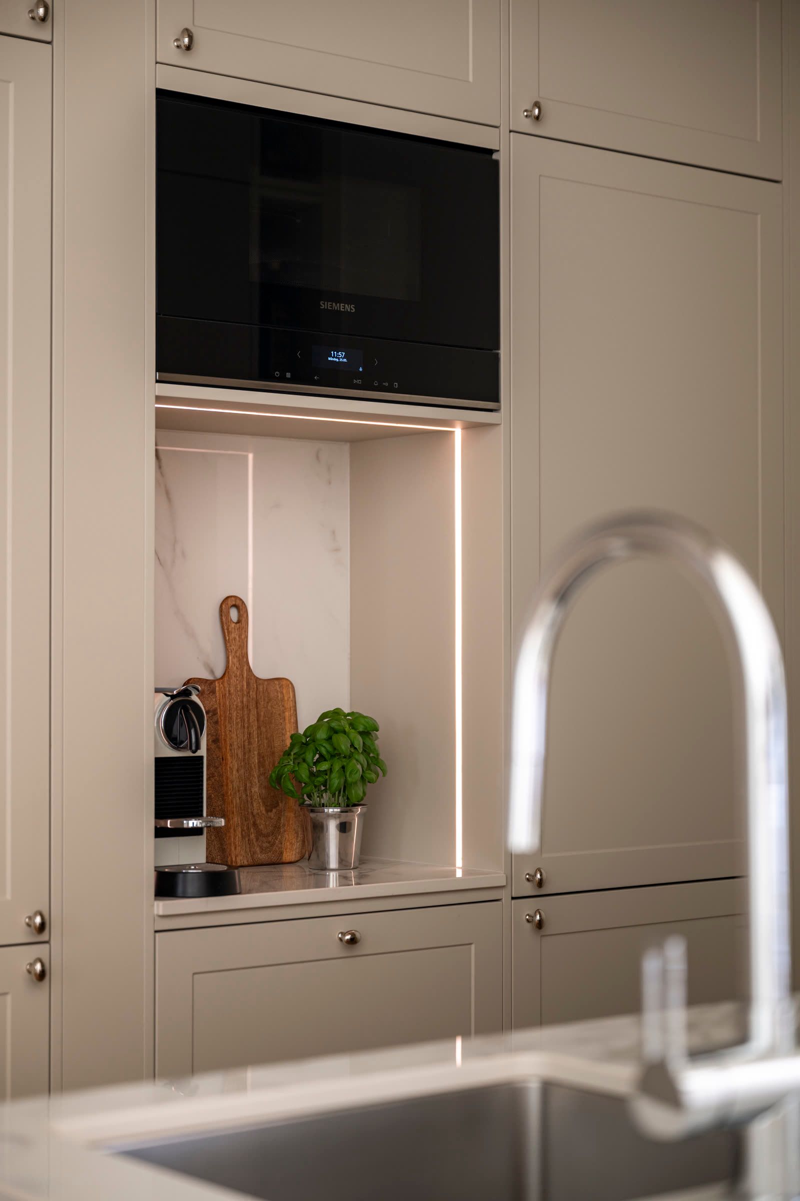 Kitchen niche with a built-in microwave and a brushed-steel tap